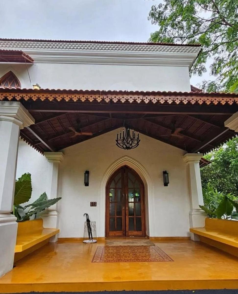 a front door of a white house with a chandelier at The Postcard Saligao in Calangute
