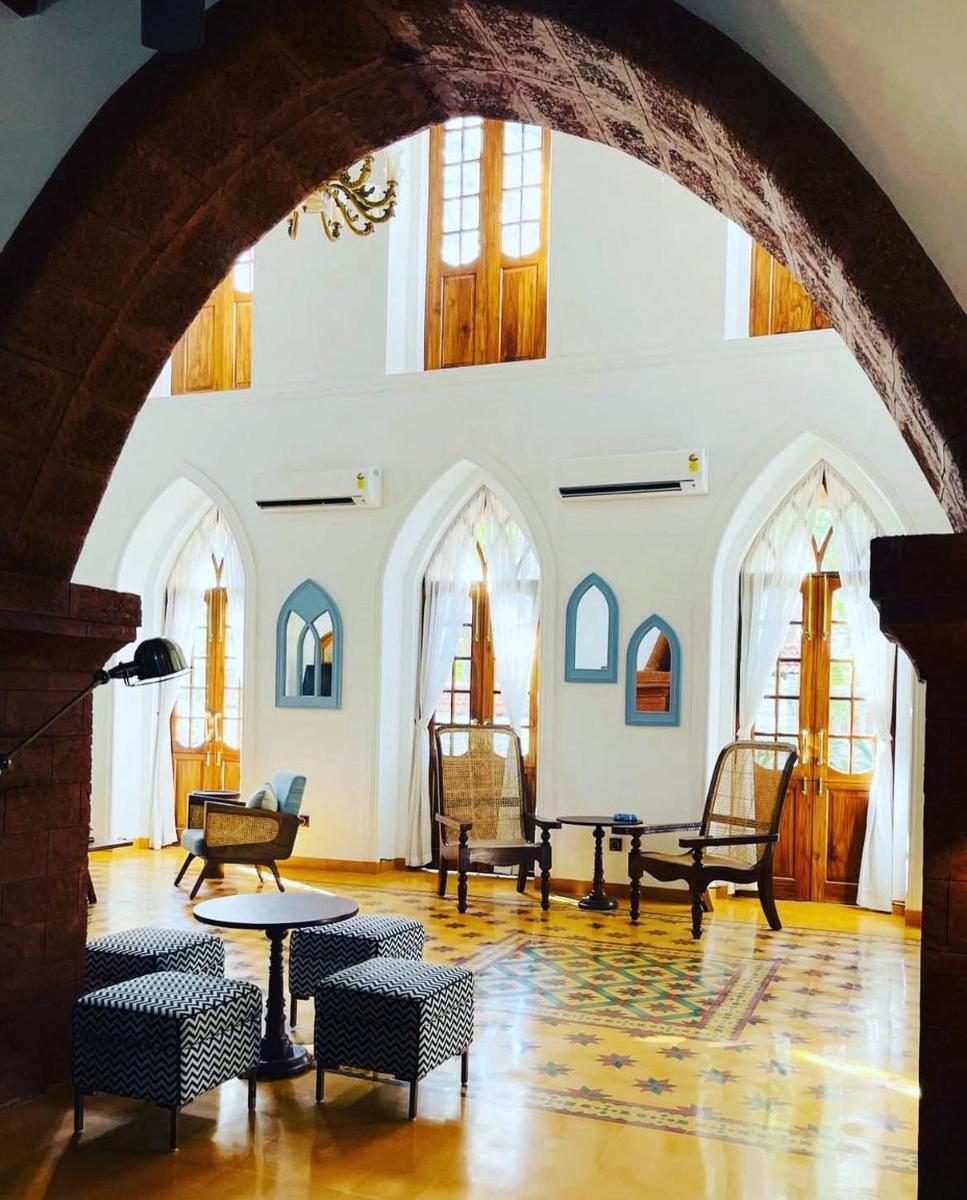 a room with chairs and tables in a building at The Postcard Saligao in Calangute