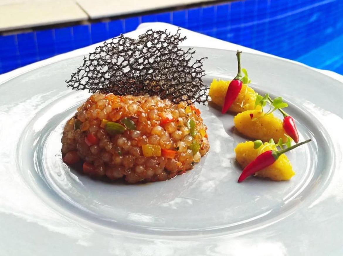 a plate of food with beans and other food items at The Postcard Saligao in Calangute