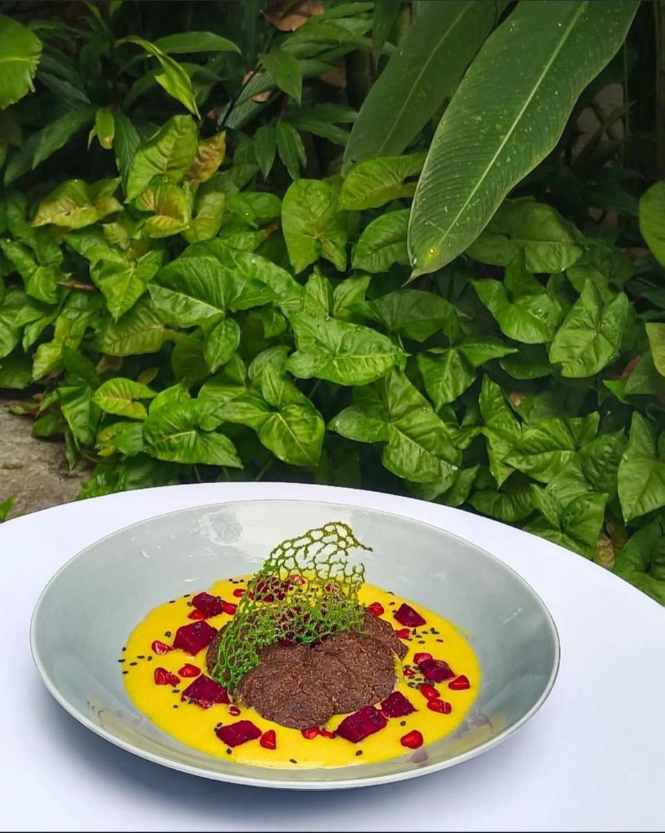 a plate with a plant on it on a table at The Postcard Saligao in Calangute