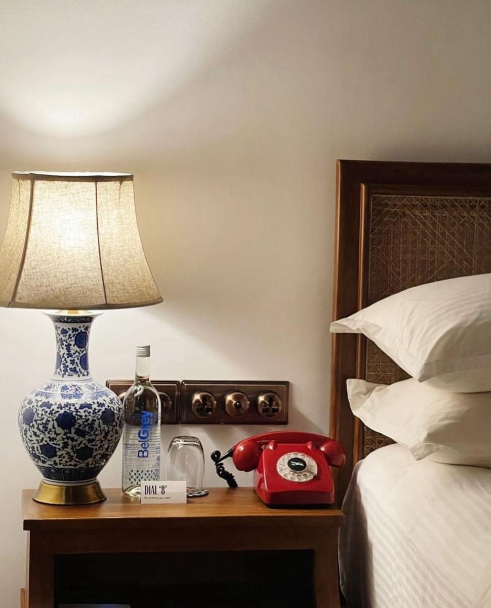 a bedroom with a bed and a lamp on a table at The Postcard Saligao in Calangute