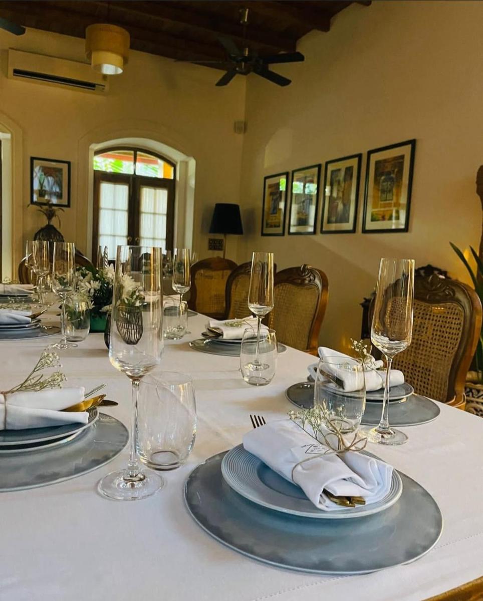 a table with glasses and plates and napkins on it at The Postcard Saligao in Calangute