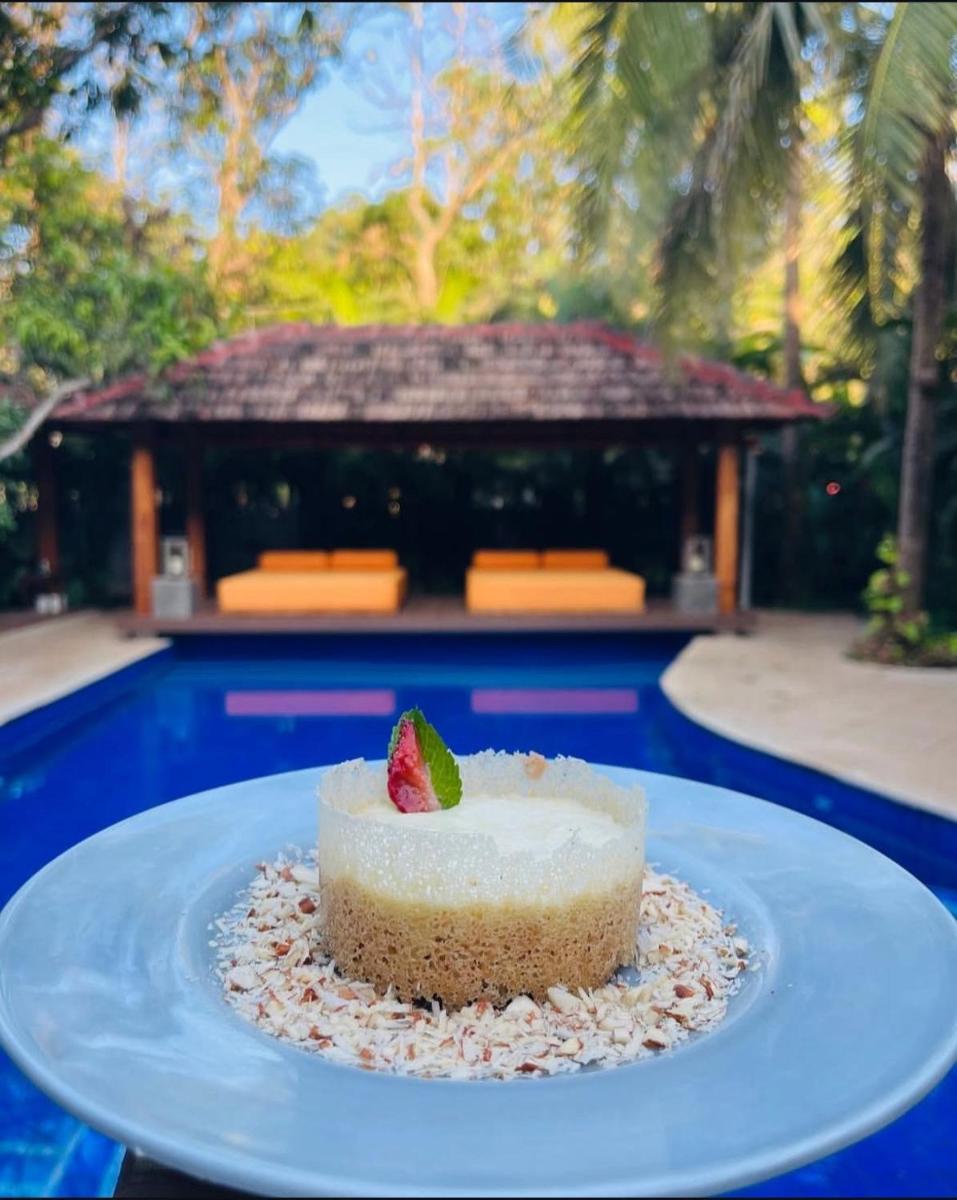 a cake on a plate with a strawberry on top at The Postcard Saligao in Calangute