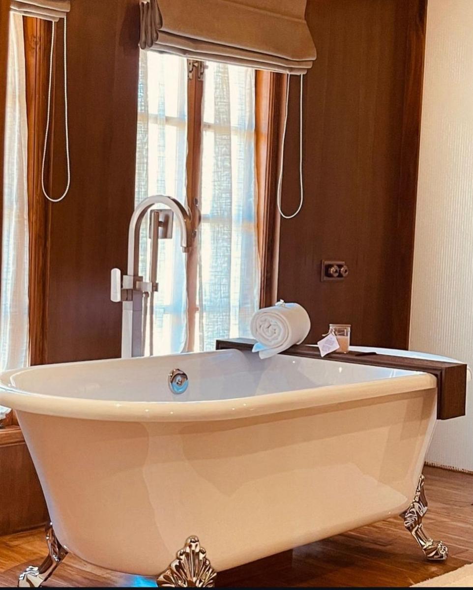 a bath tub with a faucet in a bathroom at The Postcard Saligao in Calangute