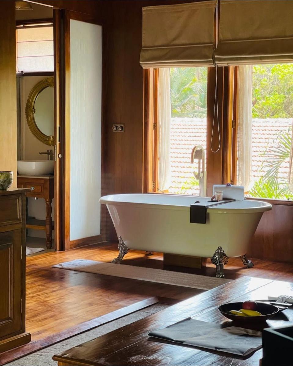 a large bath tub in a bathroom with a window at The Postcard Saligao in Calangute