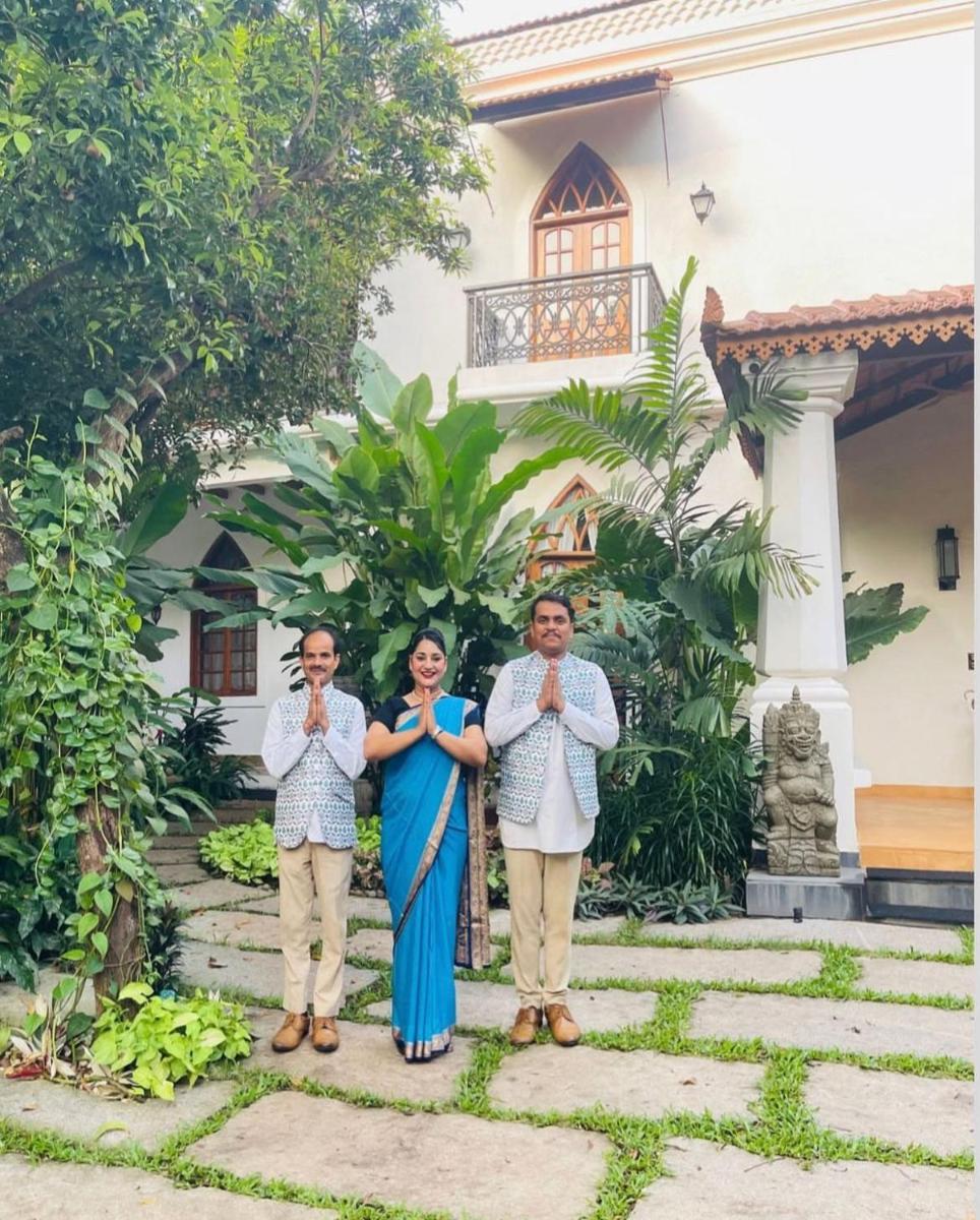 a group of three people standing in front of a house at The Postcard Saligao in Calangute