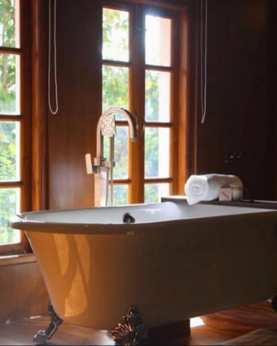 a white bath tub in a bathroom with a window at The Postcard Saligao in Calangute