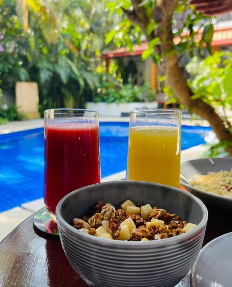 a bowl of food and two glasses of juice on a table at The Postcard Saligao in Calangute