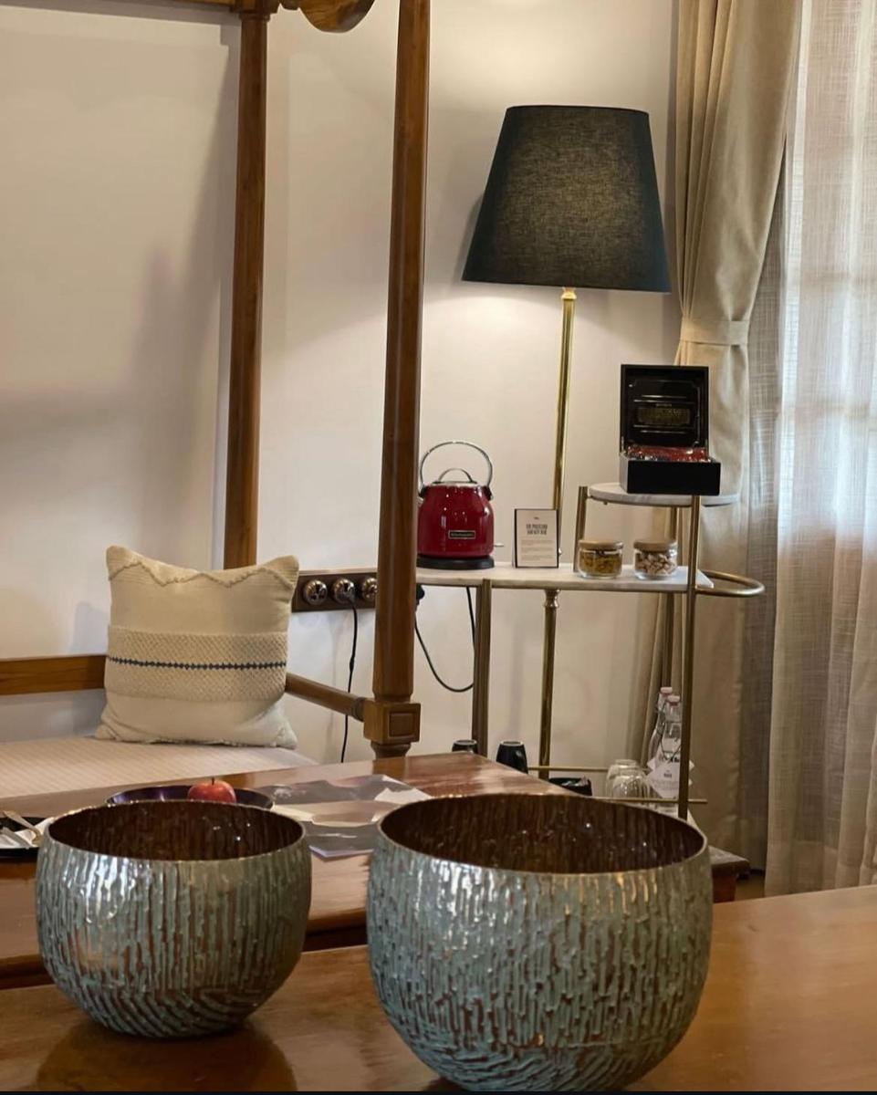 two metal bowls sitting on a table with a lamp at The Postcard Saligao in Calangute