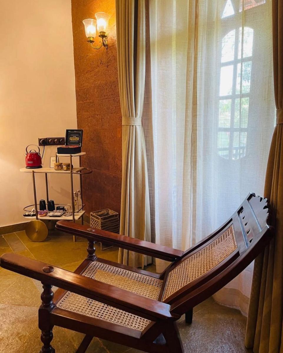 a wooden bench sitting in front of a window at The Postcard Saligao in Calangute