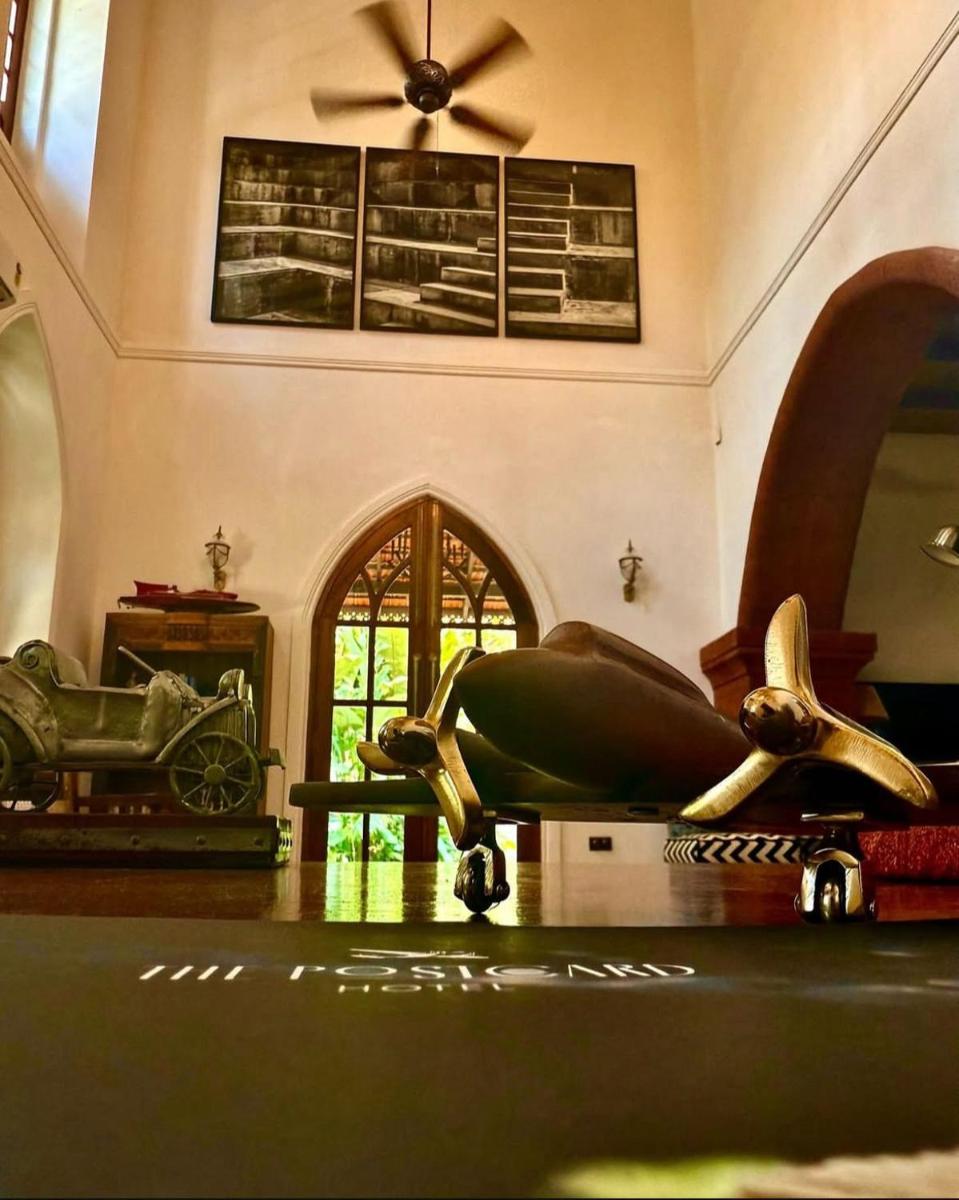 a room with a sculpture of a woman on a table at The Postcard Saligao in Calangute