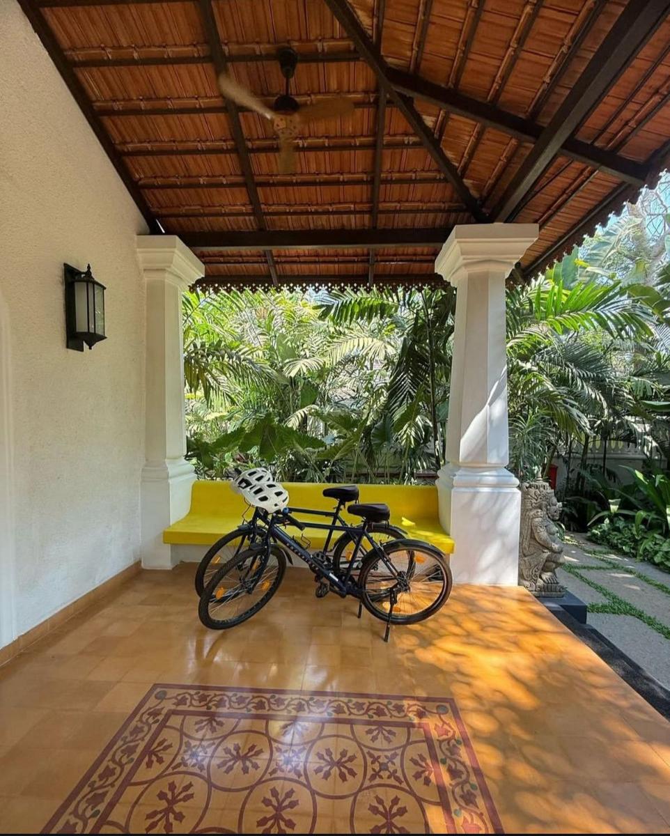 a bike parked in a room with a yellow bench at The Postcard Saligao in Calangute