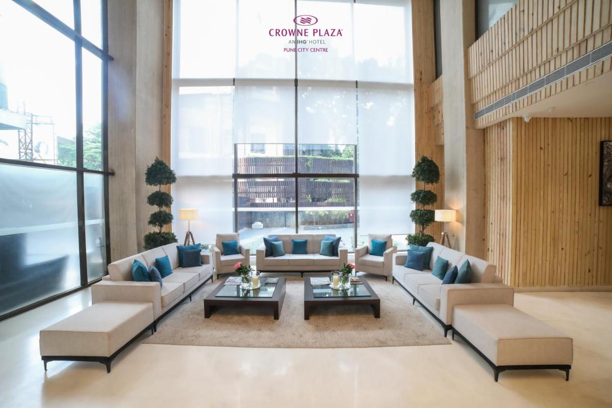 a lobby with couches and a table in a building at Crowne Plaza Pune City Centre by IHG in Pune