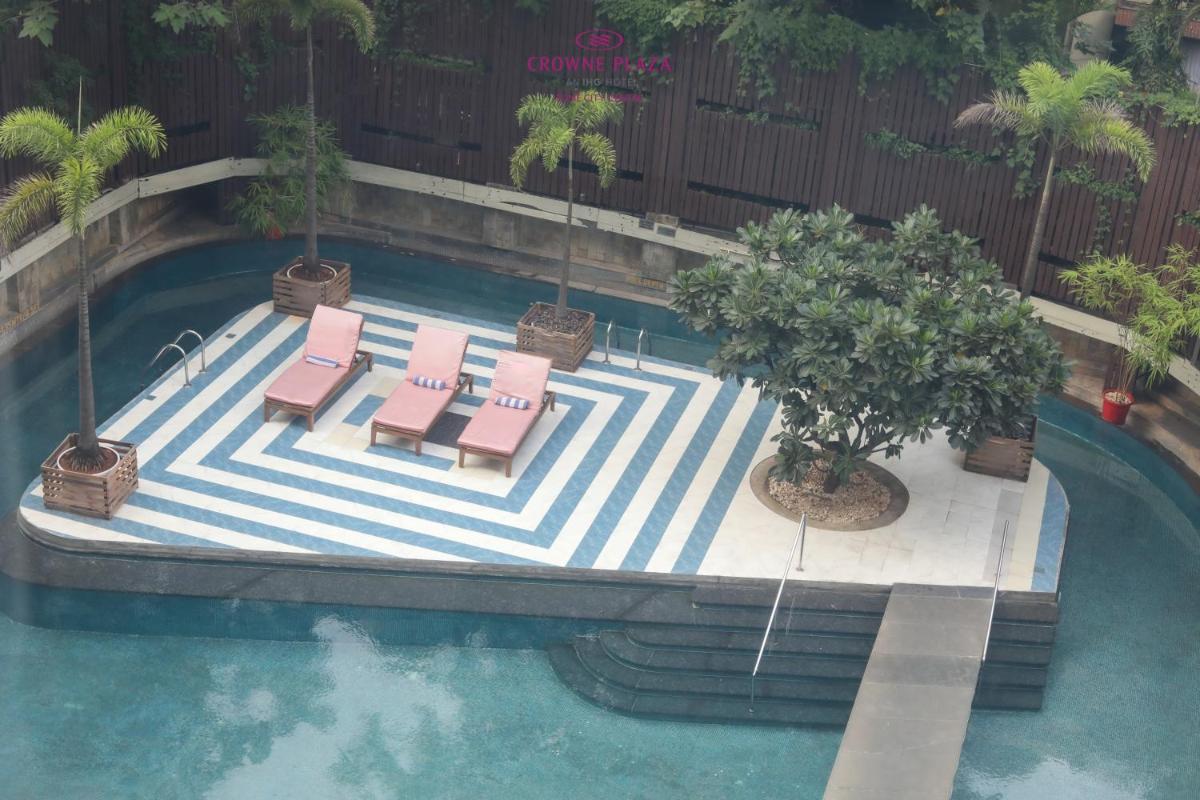 an overhead view of a swimming pool with chairs and a tree at Crowne Plaza Pune City Centre by IHG in Pune
