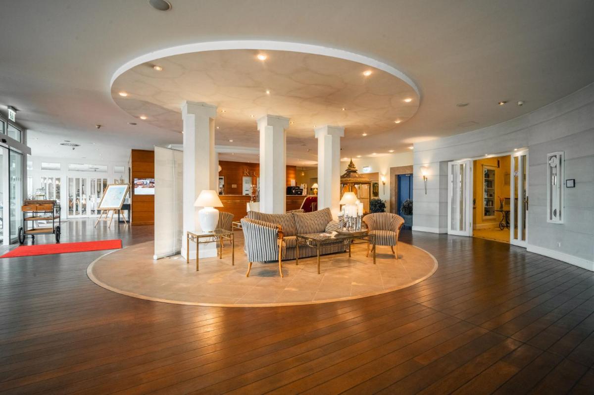 ein Wohnzimmer mit einer Couch und einem Tisch und Stühlen in der Unterkunft Grand Hotel Binz in Binz + 37 Fotos
