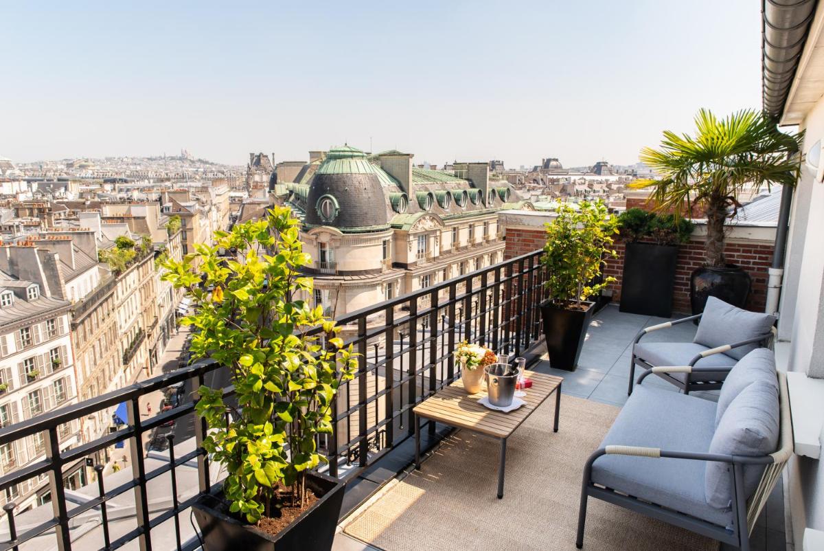 un balcon avec des chaises et une vue sur la ville dans l'établissement Hôtel Pont Royal Paris, à Paris