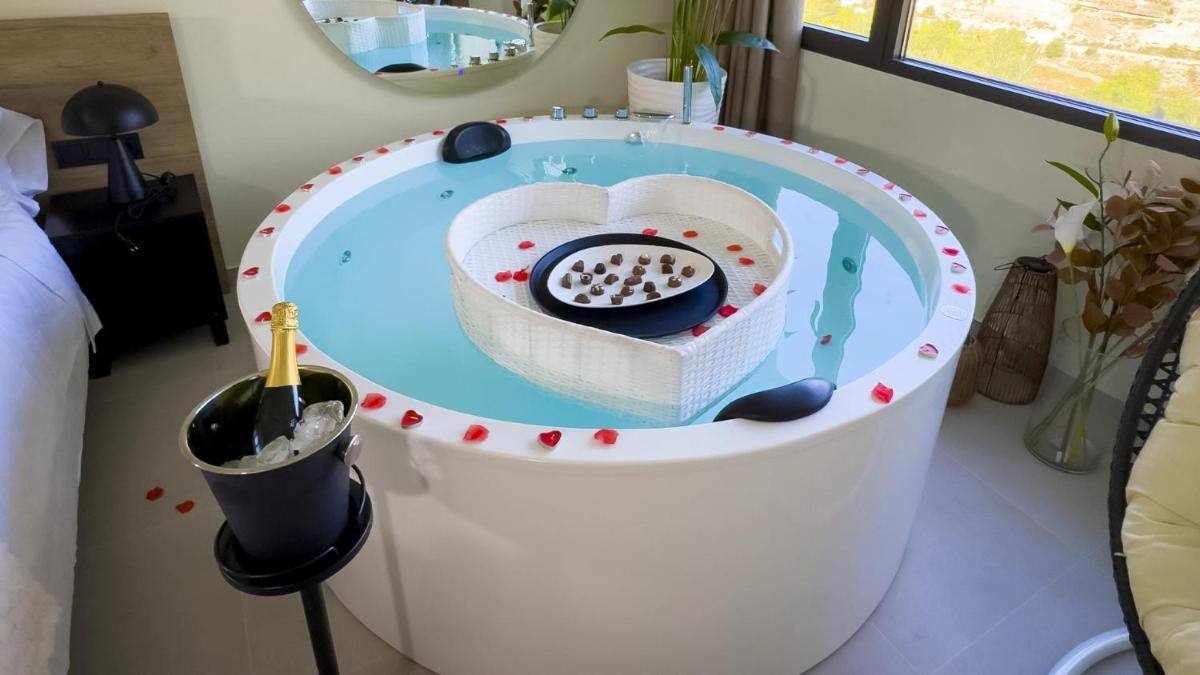 Una bañera en una habitación con un cuenco de pelotas. en Hotel Spa Mirador, en Jorquera