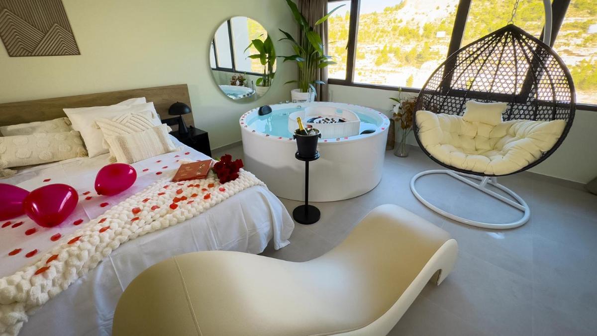 1 dormitorio con bañera, 1 cama y 1 silla en Hotel Spa Mirador, en Jorquera