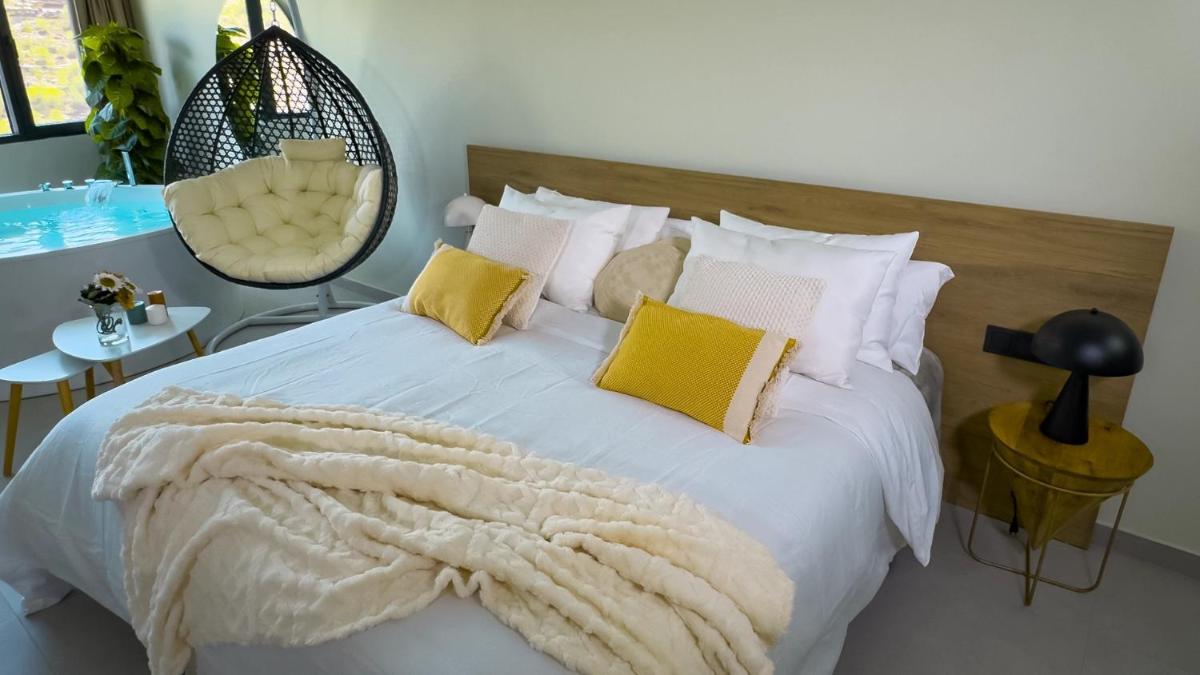Un dormitorio con una cama blanca con almohadas amarillas. en Hotel Spa Mirador, en Jorquera 65 fotos más