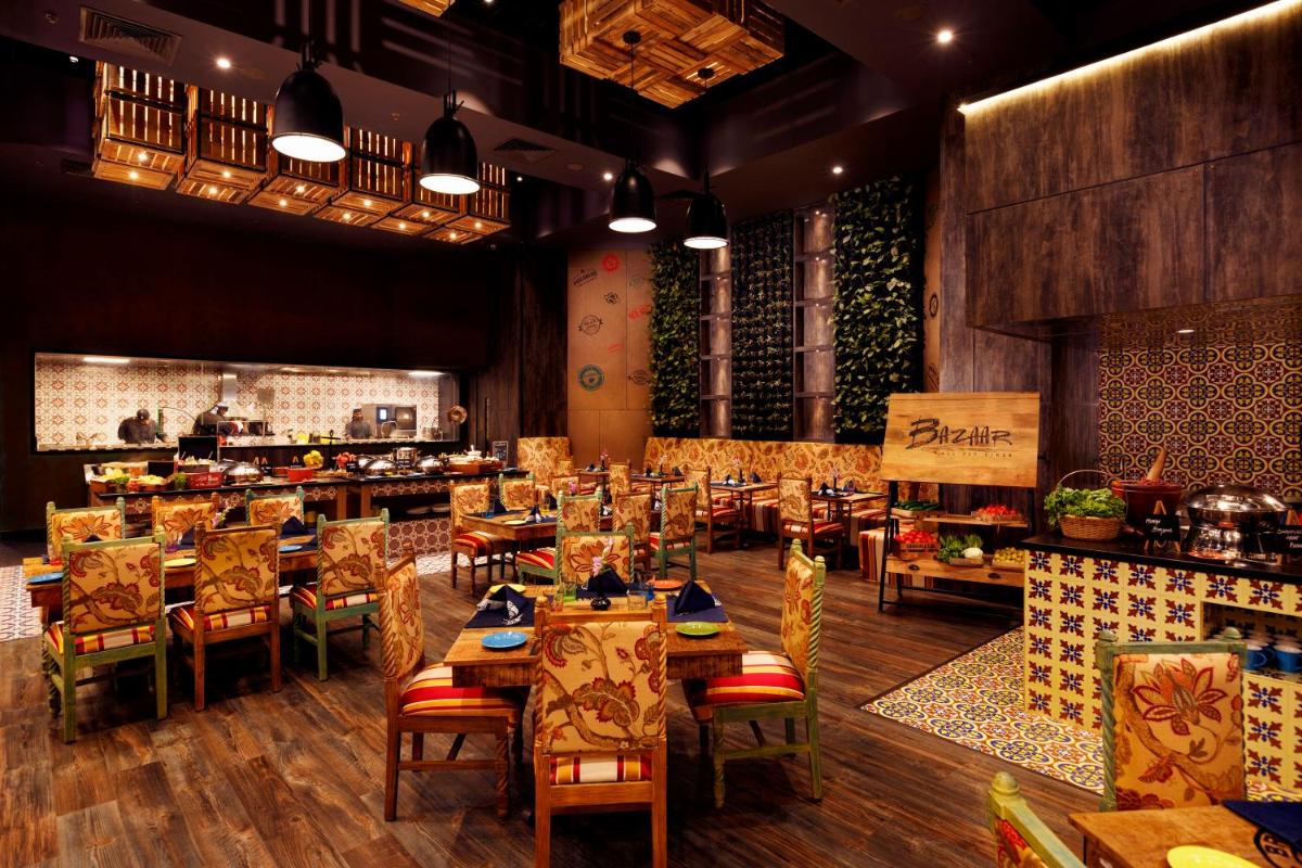 a restaurant with tables and chairs in a room at Grand Chennai by GRT Hotels in Chennai