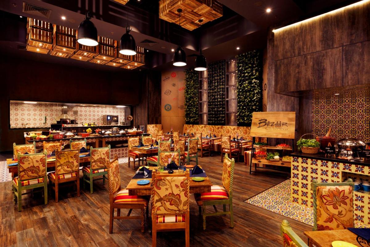 a restaurant with tables and chairs in a room at Grand Chennai by GRT Hotels in Chennai