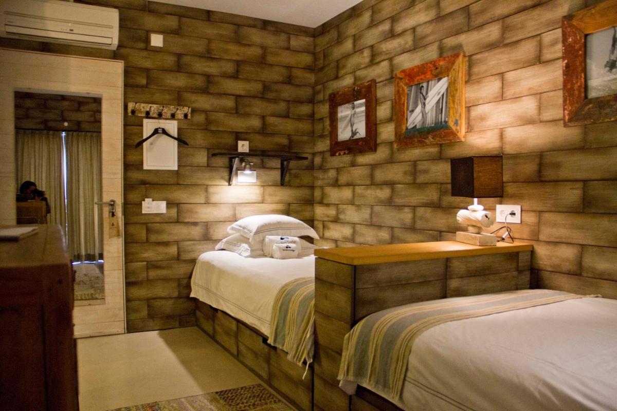 um quarto com 2 camas num quarto com paredes de madeira em Surfers Lodge Peniche em Peniche mais 46 fotografias