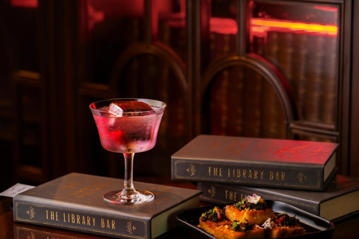 a drink on top of two boxes with a plate of food at The Leela Palace New Delhi in New Delhi a drink on top of two boxes with a plate of food at The Leela Palace New Delhi in New Delhi
