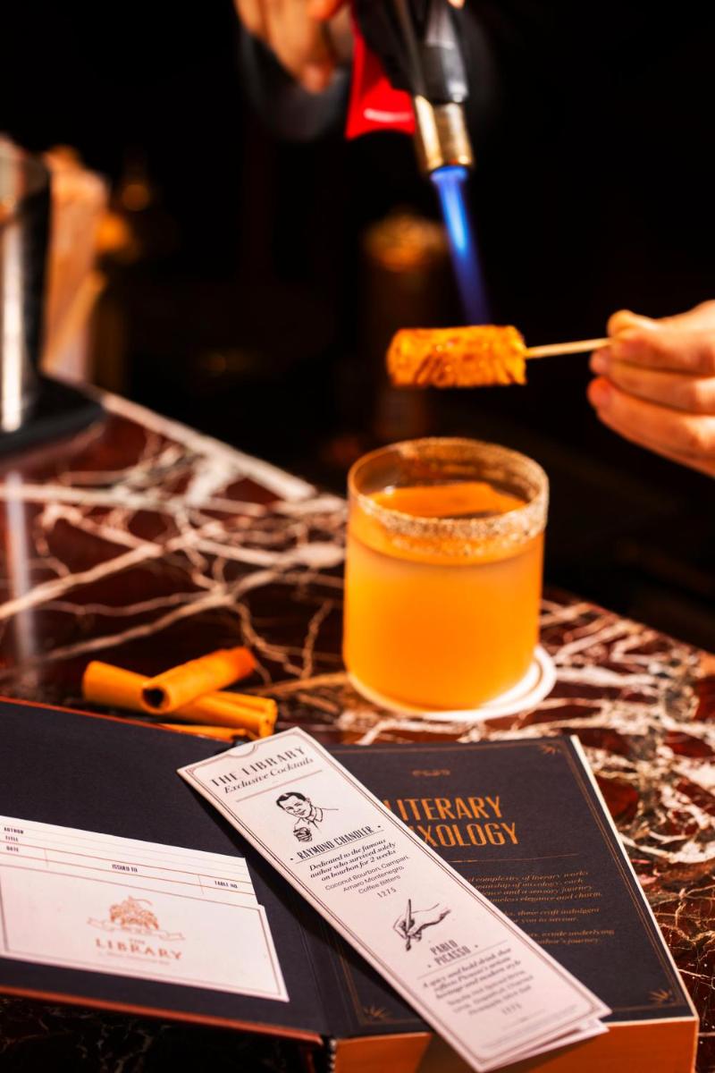 a person is stirring a drink with a spoon at The Leela Palace New Delhi in New Delhi a person is stirring a drink with a spoon at The Leela Palace New Delhi in New Delhi