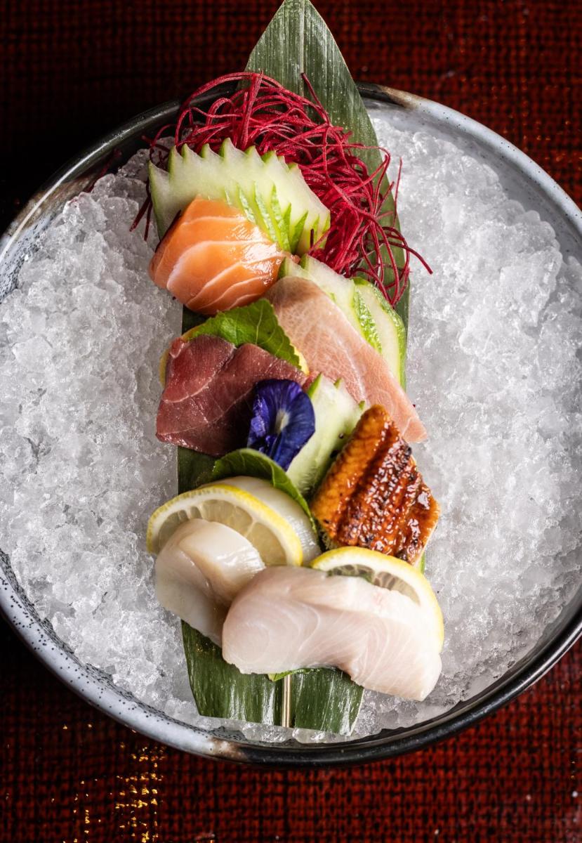 a plate of food with sushi on top at The Leela Palace New Delhi in New Delhi a plate of food with sushi on top at The Leela Palace New Delhi in New Delhi