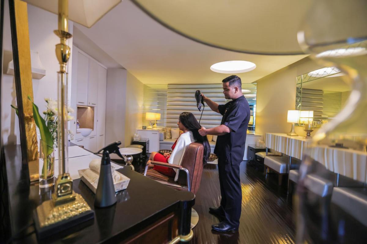 a man cutting the hair of a woman in a salon at The Leela Palace New Delhi in New Delhi a man cutting the hair of a woman in a salon at The Leela Palace New Delhi in New Delhi