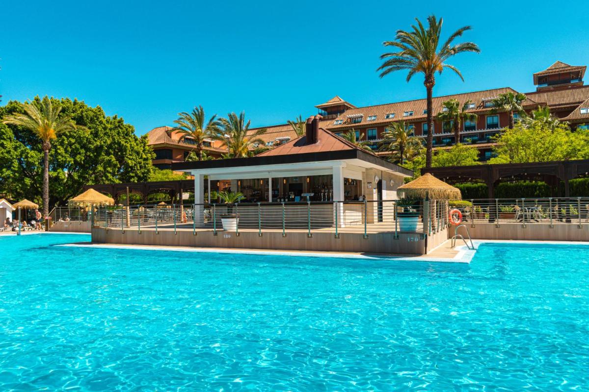 una piscina en un complejo con agua azul en Ohtels Islantilla, en Islantilla