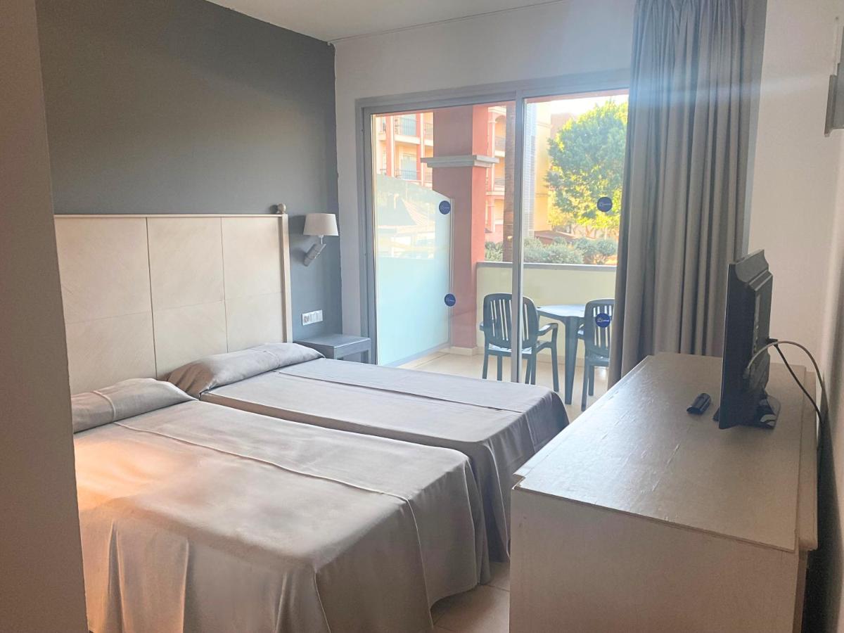 Una habitación de hotel con dos camas y un televisor. en Ohtels Islantilla, en Islantilla