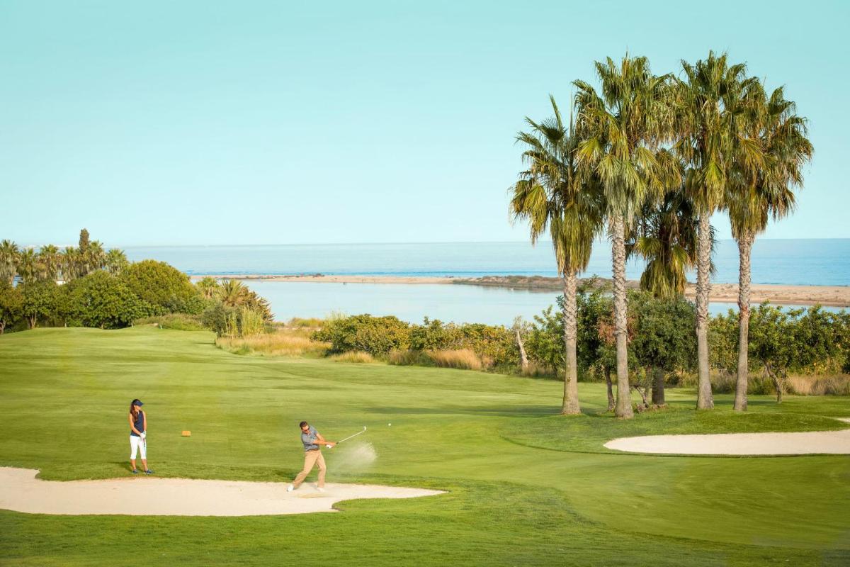 duas pessoas a jogar golfe num campo de golfe em ROBINSON QUINTA DA RIA - All Inclusive em Vila Nova de Cacela