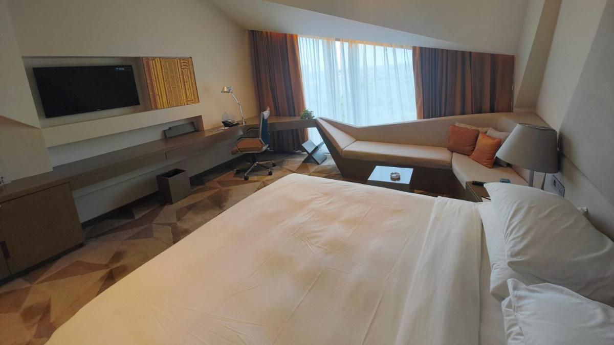 a hotel room with a bed and a couch at Vivanta New Delhi, Dwarka in New Delhi a hotel room with a bed and a couch at Vivanta New Delhi, Dwarka in New Delhi