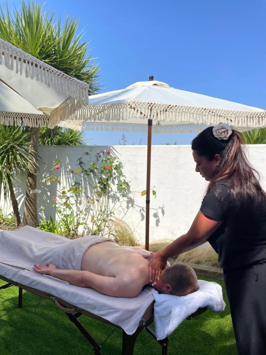 une femme en train de baiser un homme sur une serviette sur un lit dans l'établissement Hôtel Ancre Marine & Spa Thalgo ***, à Noirmoutier-en-l'lle
