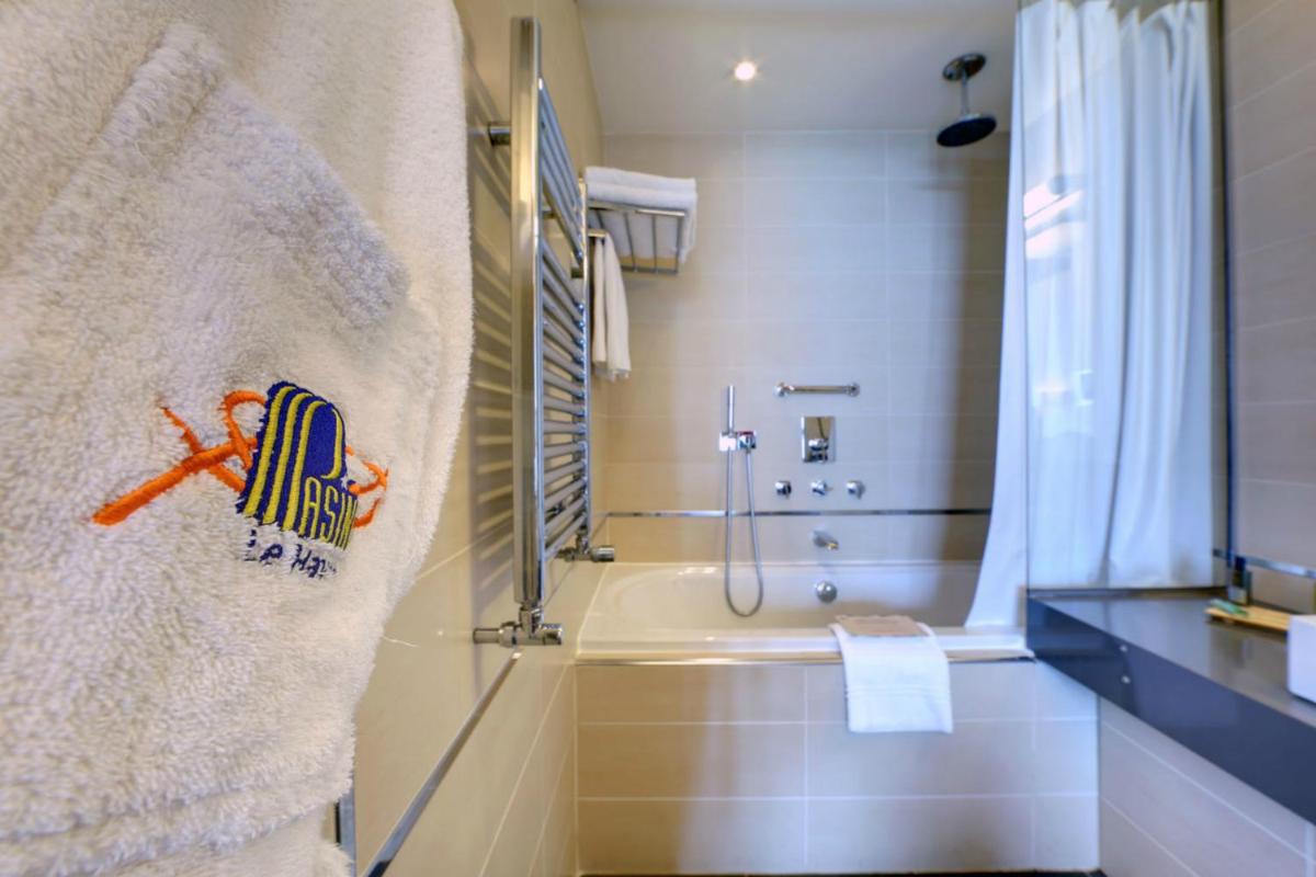 une salle de bain avec une douche, une baignoire et un lavabo dans l'établissement Hotel Spa Le Pasino, au Havre