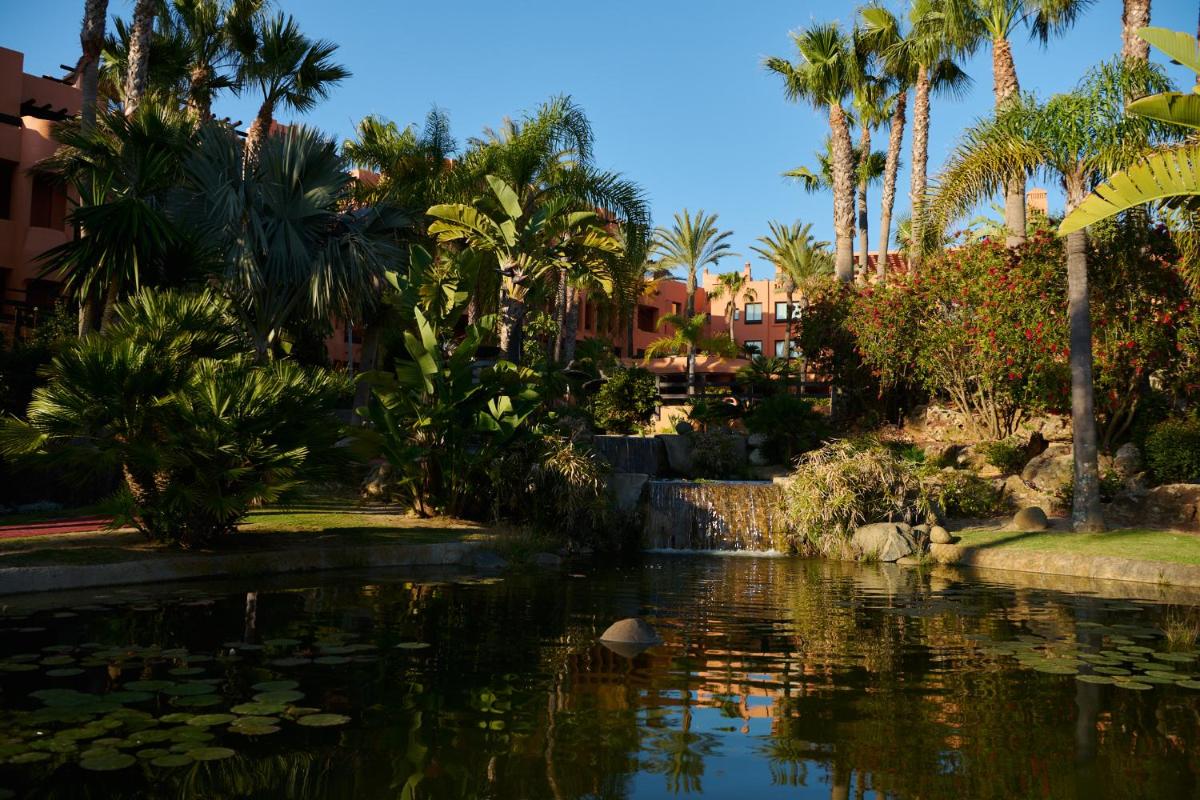 un estanque en un parque con palmeras y un estanque sidx sidx sidx en Aparthotel Novo Resort, en Novo Sancti Petri