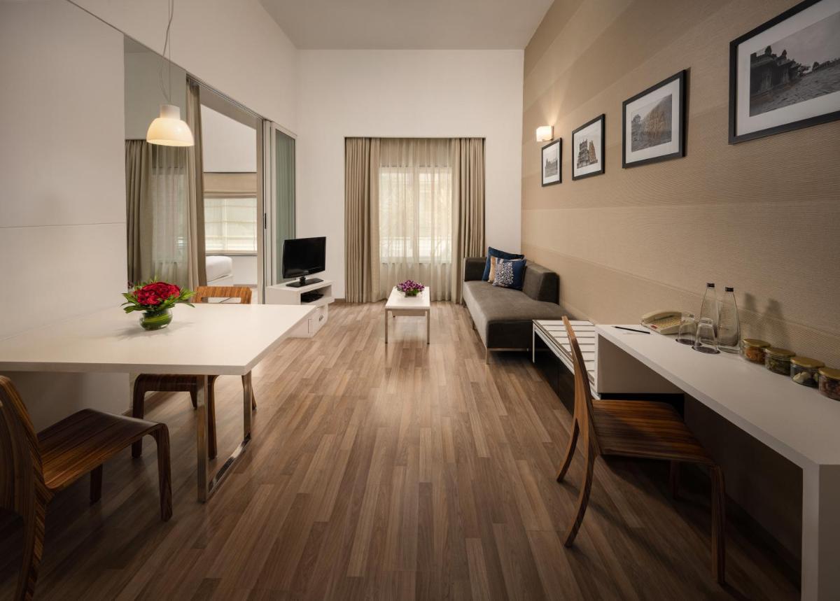 a living room with a couch and a dining room at Grand Mercure Bangalore - An Accor Brand in Bengaluru