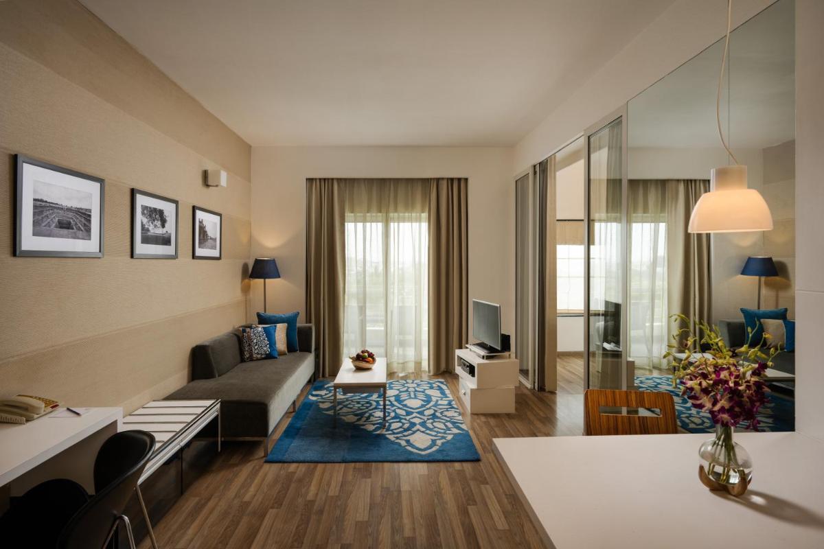 a living room with a couch and a table at Grand Mercure Bangalore - An Accor Brand in Bengaluru