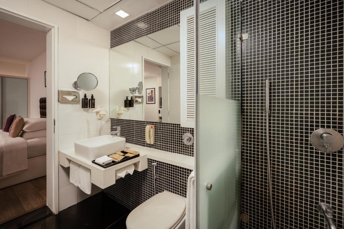 a bathroom with a toilet and a sink and a shower at Grand Mercure Bangalore - An Accor Brand in Bengaluru a bathroom with a toilet and a sink and a shower at Grand Mercure Bangalore - An Accor Brand in Bengaluru