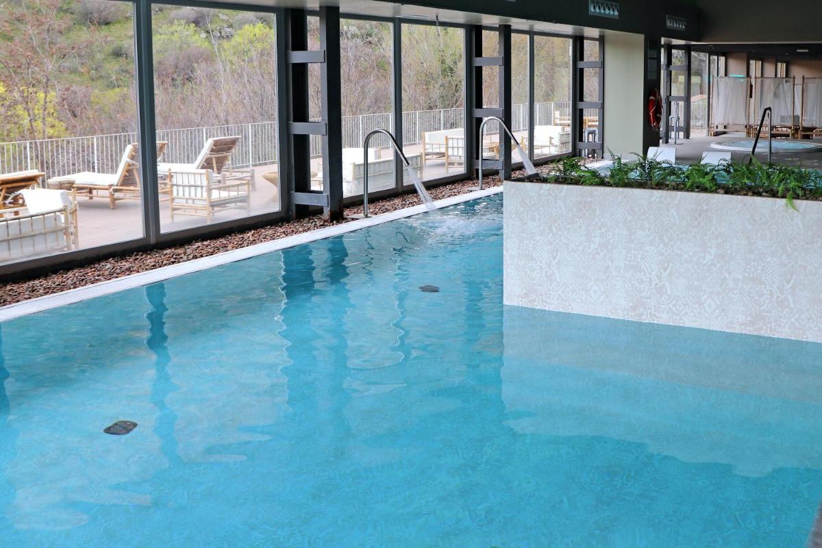 una piscina con agua azul en un edificio en Balneario Segura de Baños, en Segura de los Baños