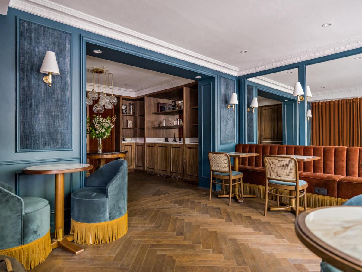 un restaurant avec des murs bleus, des chaises et des tables dans l'établissement Hotel Duquesne Eiffel, à Paris