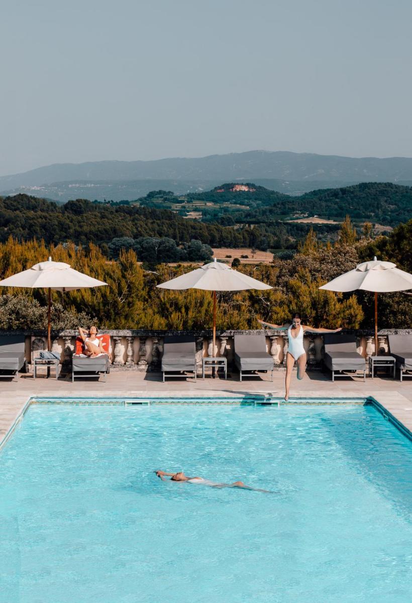 une personne dans la piscine d'un hôtel dans l'établissement Le Phébus & Spa – Relais & Châteaux, à Joucas