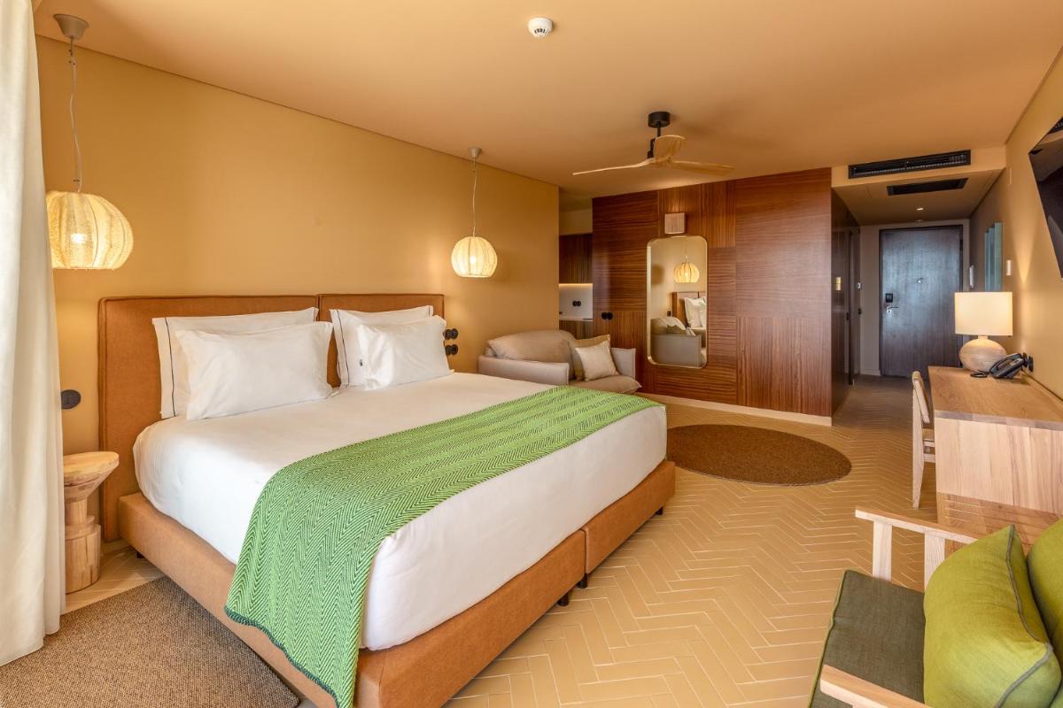 um quarto com uma cama grande e uma sala de estar em 3HB Falesia Beach em Albufeira