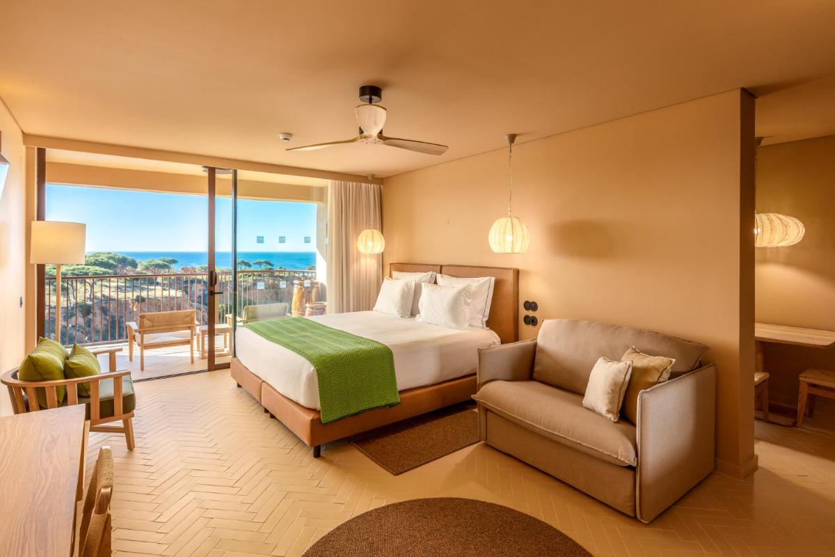 um quarto de hotel com uma cama e um sofá em 3HB Falesia Beach em Albufeira