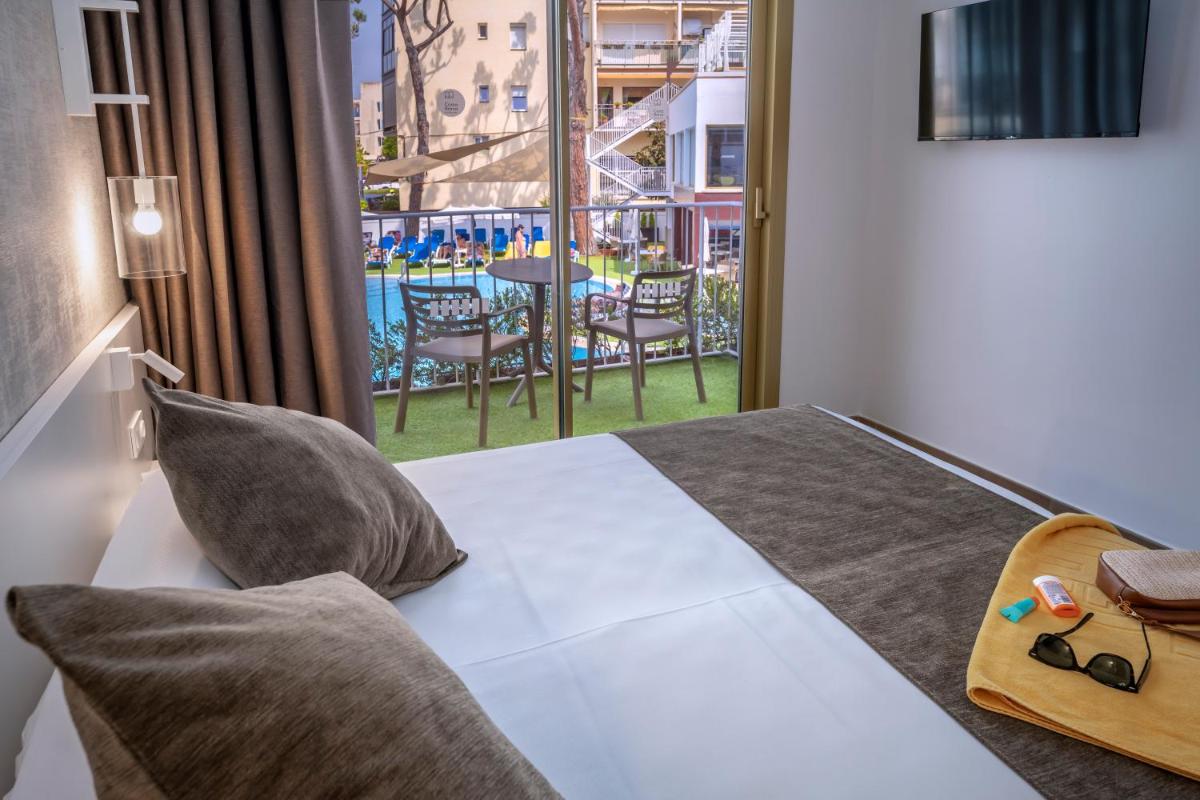Un dormitorio con una cama con vista a un patio. en GHT Costa Brava & Spa, en Tossa de Mar