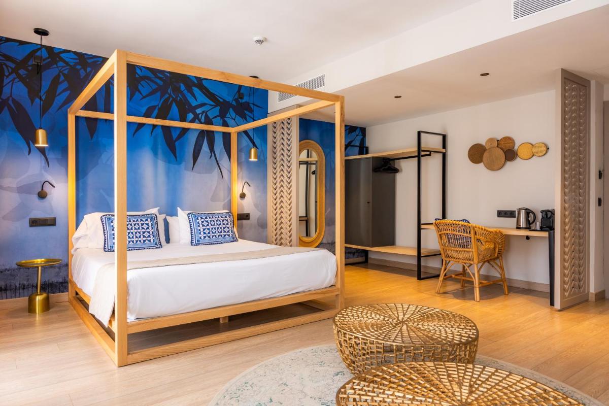 1 dormitorio con cama con dosel y mesa en Marins Beach Club - Adults Only Hotel, en Cala Millor