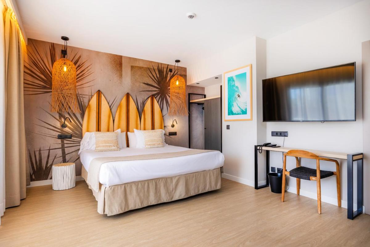1 dormitorio con 1 cama con tablas de surf en la pared en Marins Beach Club - Adults Only Hotel, en Cala Millor