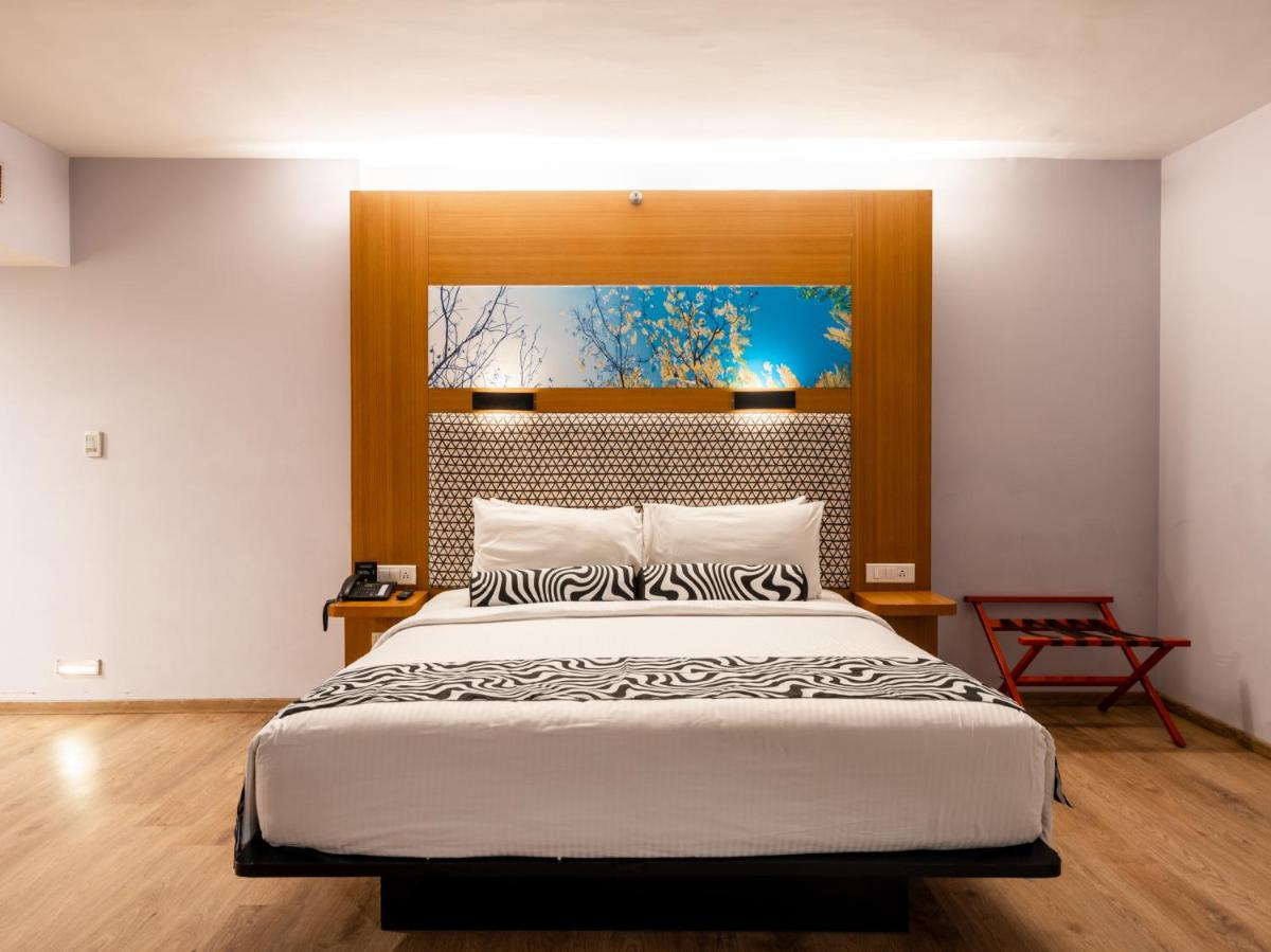 a bedroom with a large bed in a room at Sunday Hotel Chandigarh Zirakpur in Zirakpur