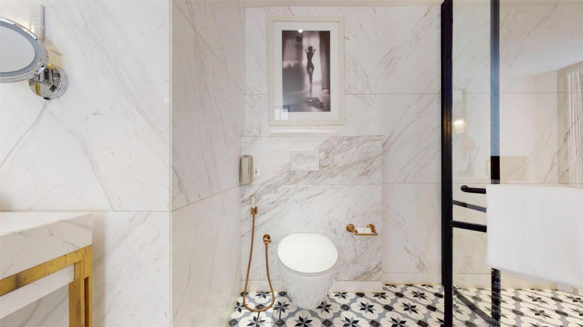 a white bathroom with a toilet in a shower at Radisson Hotel Shimla in Shimla